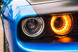 The front double headlight of a sports blue car. Orange headlight