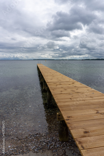 view of a long wooden pier leading out into clear ocean waters