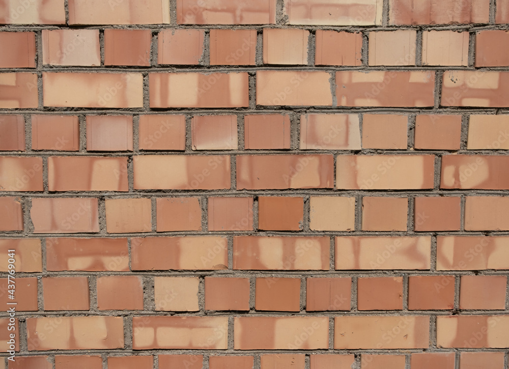 Fototapeta premium A piece of red textured brickwork. Natural look, with cracks, cement smudges, dirty spots.