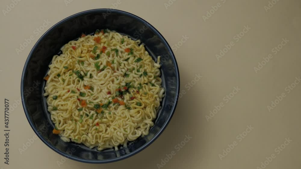 Cooking instant noodles in a dark blue bowl. Timelapse. View from above Cooking instant noodles in a dark blue bowl. Timelapse. View from above