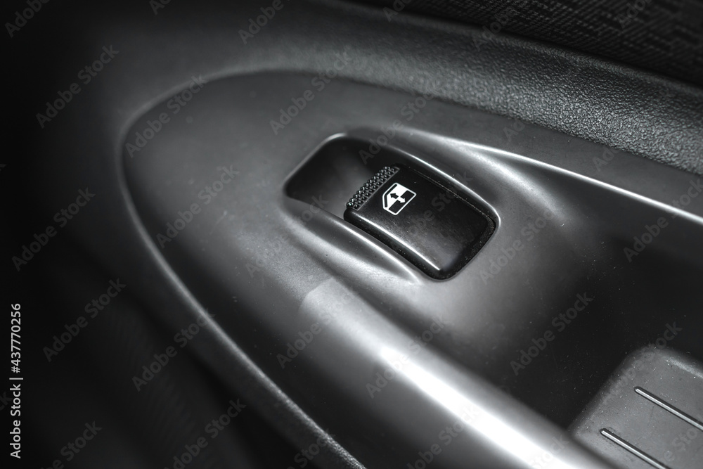 Black car window lifter button in car door close-up background Black car window lifter button in car door close-up background