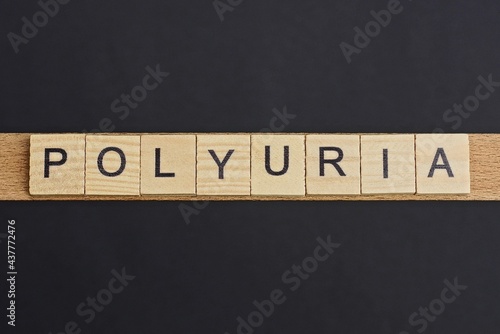 text on word polyuria from gray wooden letters on a black background photo