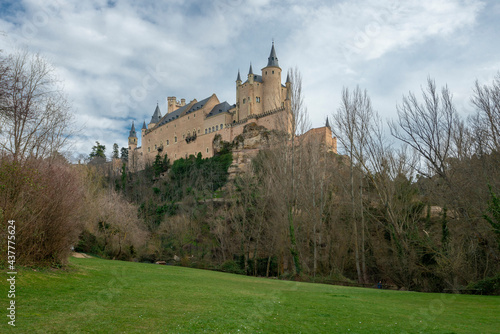 Classic view of the beautiful Alcazar de Segovia in Castilla, Spain. With a green meadow in the foreground