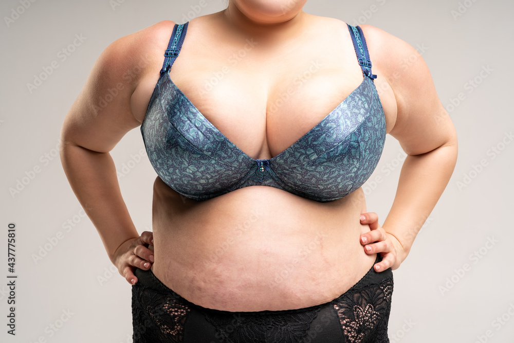 Big natural breasts in blue bra, biggest boobs on gray background Stock  Photo