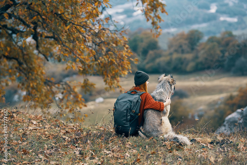 woman hiker hugging with dog on nature in the mountains travel friendship