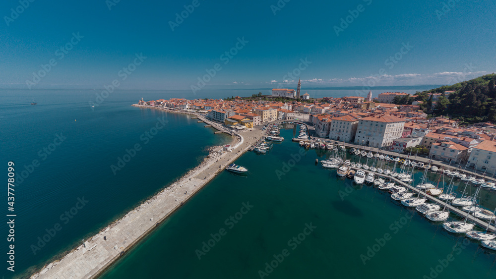 Aerial view of boats moored in the tartini square in piran, different boats resting on the edge of Piran marina.