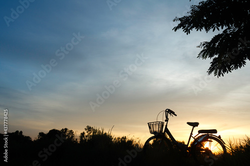 Silhouette of Bicycle and beautiful landscape.Bike at sunset on grass field meadow.Sports,outdoor activities, Healthy,Lifestyle.Photo concept of Silhouette and Sport.