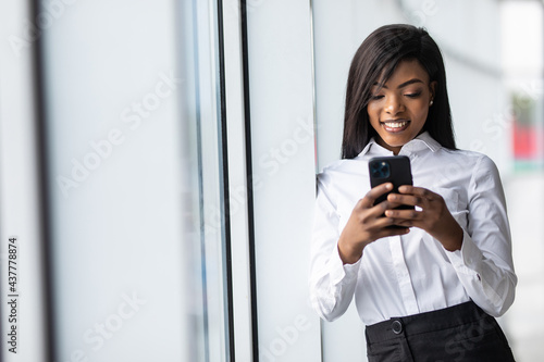 Young African American woman look at smartphone screen text message online in office © F8  \ Suport Ukraine