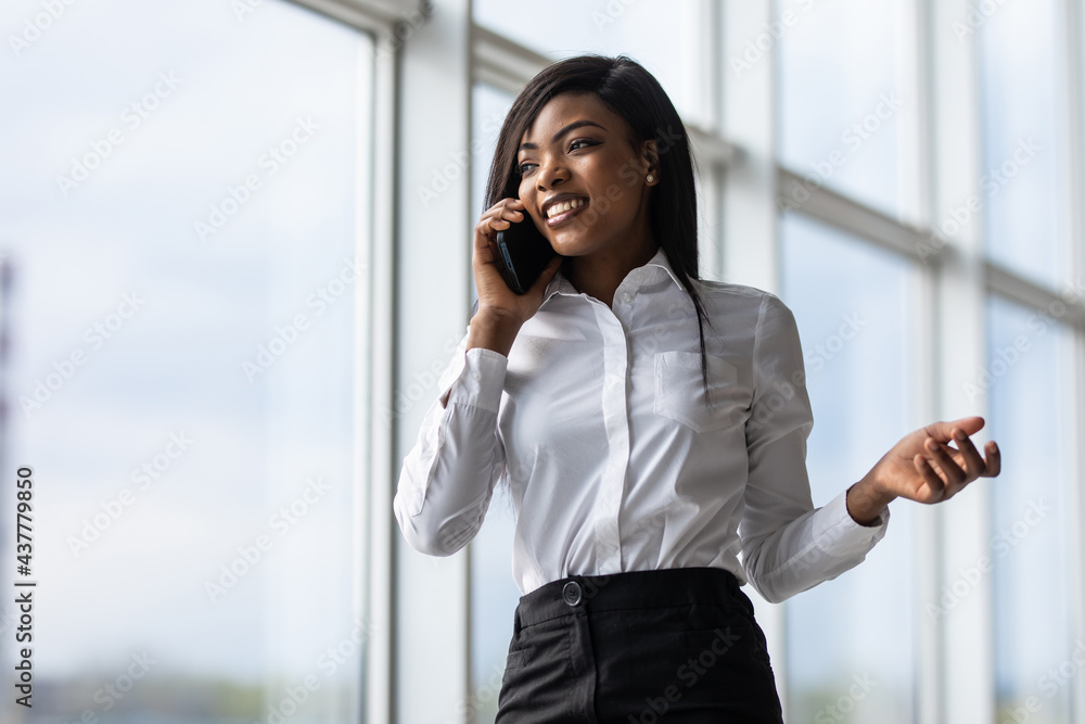 attractive african american office worker talking on the phone in office attractive african american office worker talking on the phone in office
