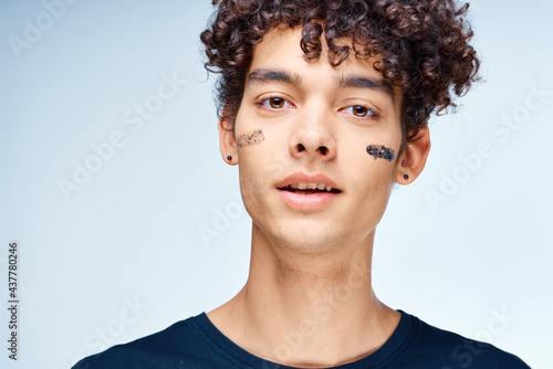 Cheerful man with curly hair cosmetics on face clean skin