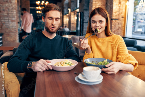 a man and a woman are sitting at a table in a restaurant meal delicious food serving dishes