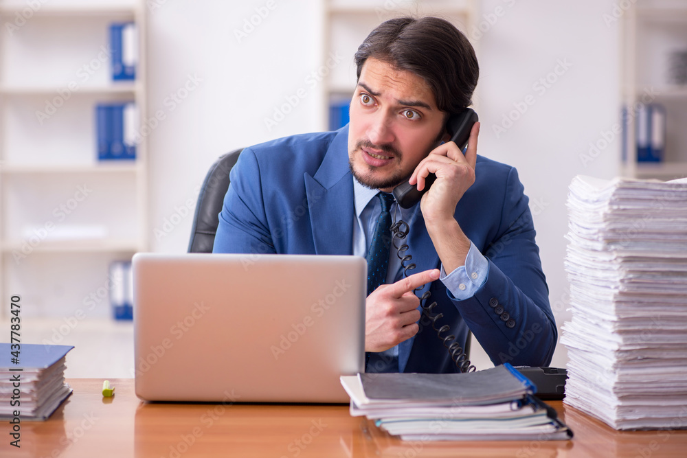 Young businessman employee and too much work in the office