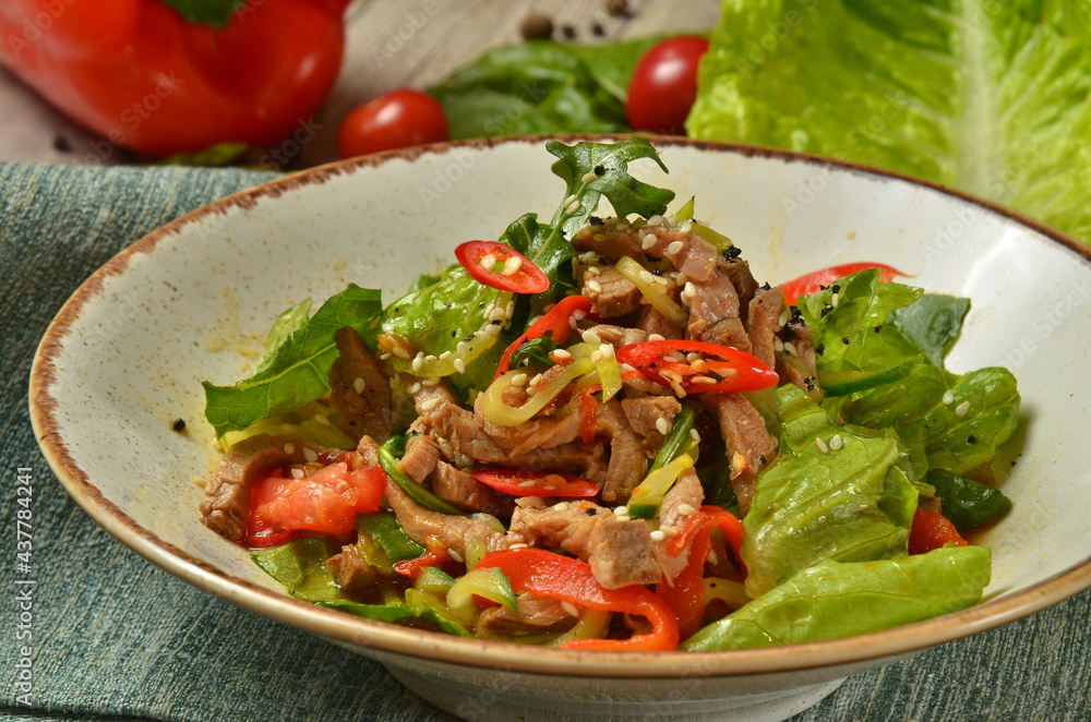 Warm salad with veal. Tasty and nutritious food with ingredients on rustic background