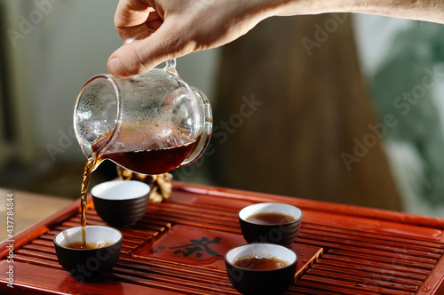 Young girl pouring tea teapot close, Chinese tea ceremony.