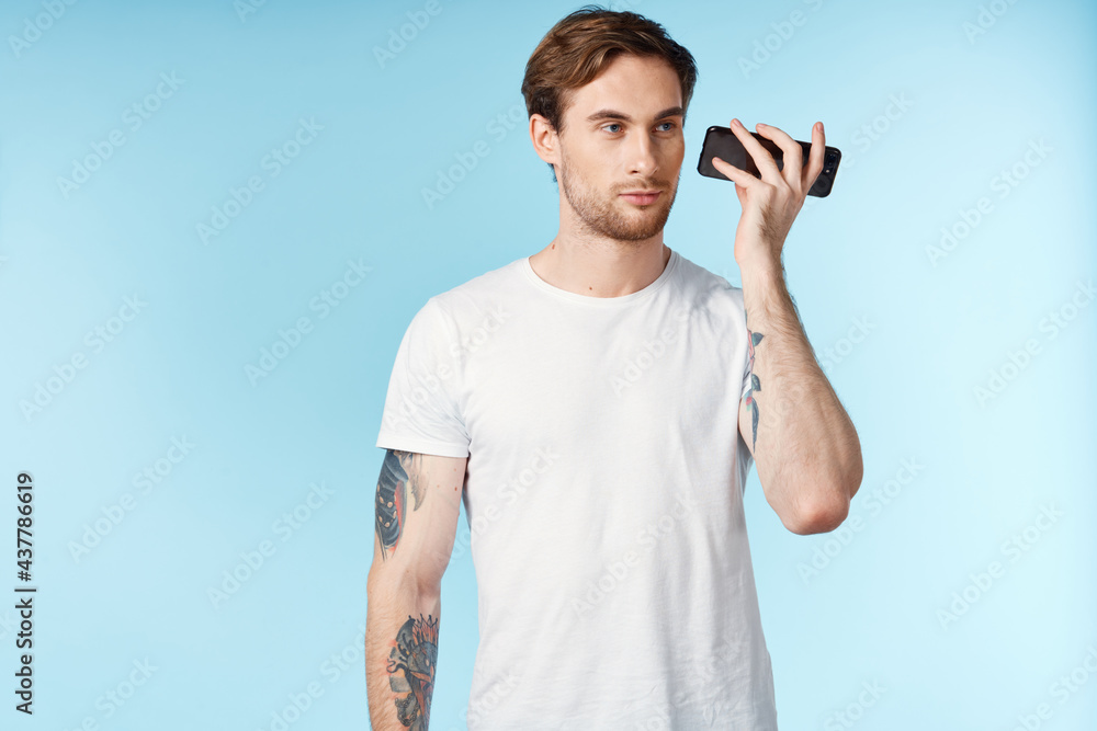 man with tattoos on his arms white t-shirt cropped view blue background man with tattoos on his arms white t-shirt cropped view blue background