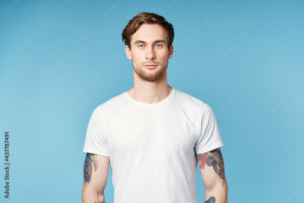 man with tattoos on his arms white t-shirt cropped view blue background man with tattoos on his arms white t-shirt cropped view blue background
