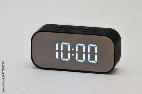 Electronic clock with digital indication of time and date on a white background
