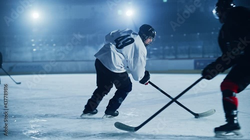 Ice Hockey Rink Arena: Young Players Training, Learning Stick and Puck Handling. Athletes Learn how to Dribble, Attack, Defend, Protect, Possession, Drive the Puck. Cinematic Slow Motion Shot photo