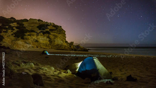 two tents on a beach at night with stars above and rock in background, Figueira, Portugal