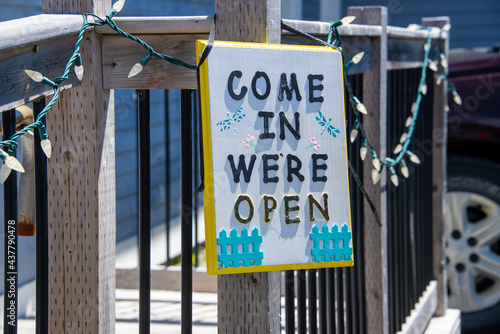 Obraz na plátně A colorful white wooden sign on a cafe with the words come in we're open