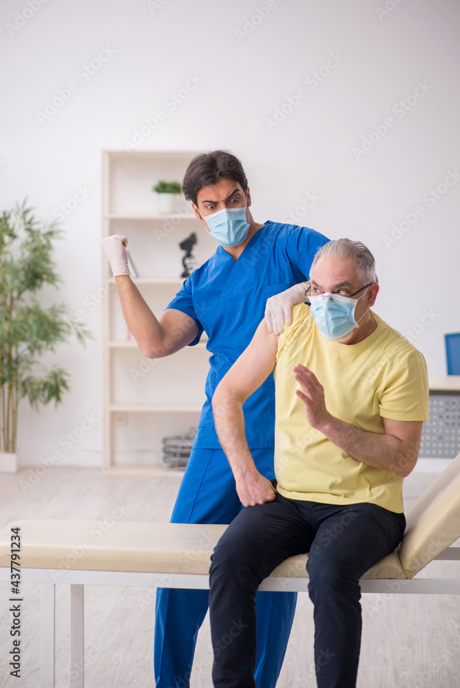 Old male patient visting young male doctor in vaccination concep Old male patient visting young male doctor in vaccination concep