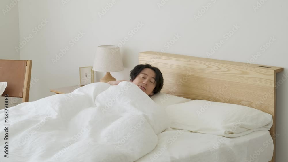 ベッドから起床する男性 ベッドから起床する男性