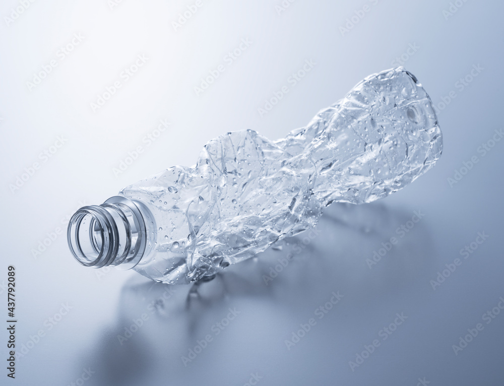 A crushed plastic bottle on a gray background. A crushed plastic bottle on a gray background.