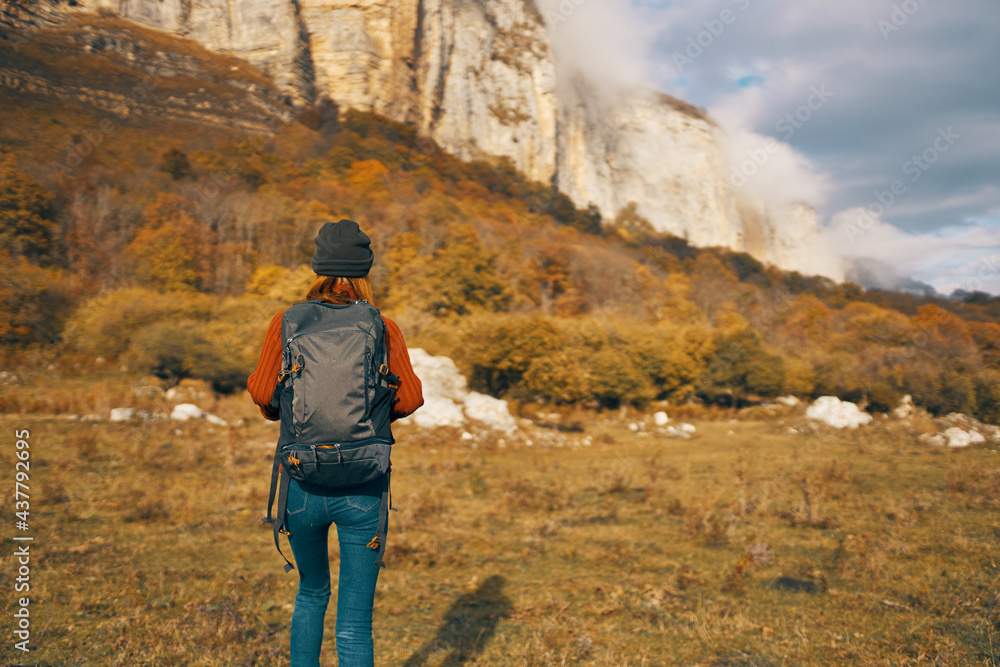 Naklejka premium woman with backpack travels in nature and climb mountains