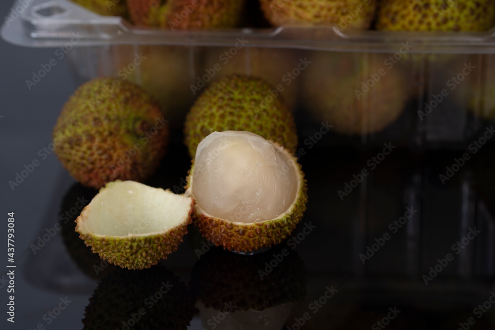 A close-up of a peeled green lychees with blurred whole fruit in the background. Selective focus points. A close-up of a peeled green lychees with blurred whole fruit in the background. Selective focus points.