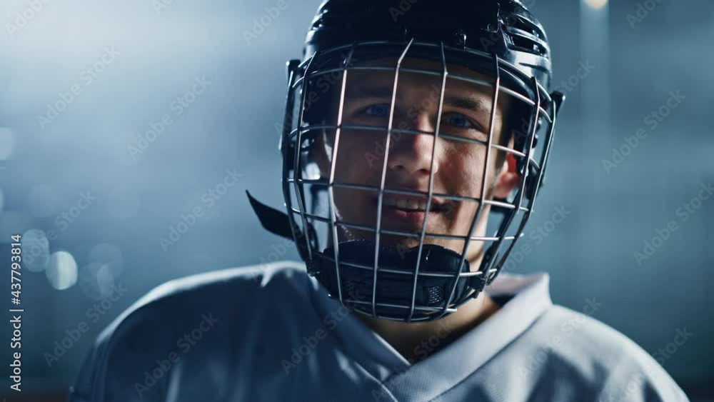 Ice Hockey Arena: Portrait of Confident Professional Player, Wearing Wire Cage Face Mask, Looking at Camera and Smiling. Close-up Shot Ice Hockey Arena: Portrait of Confident Professional Player, Wearing Wire Cage Face Mask, Looking at Camera and Smiling. Close-up Shot