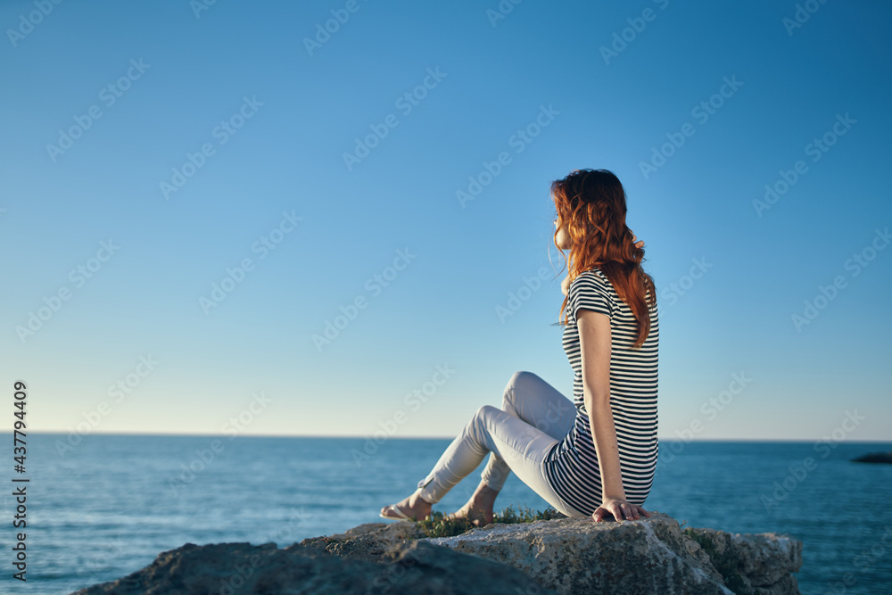 Woman hiker on a rock near the sea sunset blue sky and transparent water model