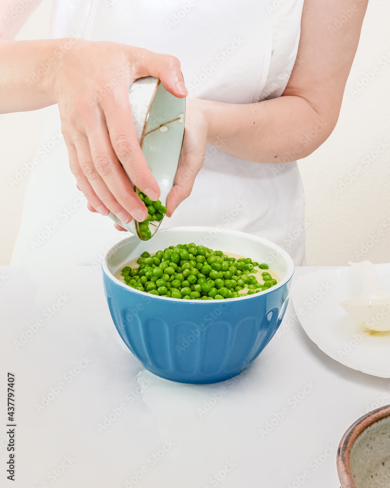 Green peas in a bowl. Step by step creamy pureed celery soup with fresh green peas recipe, woman hands, vertical banner