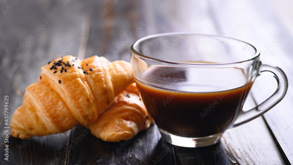 French croissant with black sesame seeds and coffee cup on wooden background, morning breakfast French croissant with black sesame seeds and coffee cup on wooden background, morning breakfast