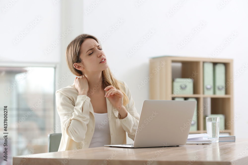 Woman suffering from neck pain in office. Symptom of bad posture
