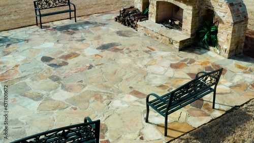 Overhead shot of a natural flagstone patio hardscape with an elegant wood-burning fireplace at an upscale event venue