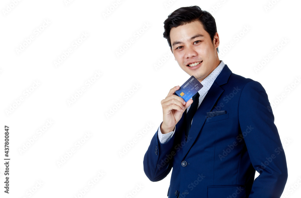 Young attractive asian business man wearing navy blue suit with white shirt and necktie smiling and holding his blue credit card up on white background isolated Young attractive asian business man wearing navy blue suit with white shirt and necktie smiling and holding his blue credit card up on white background isolated