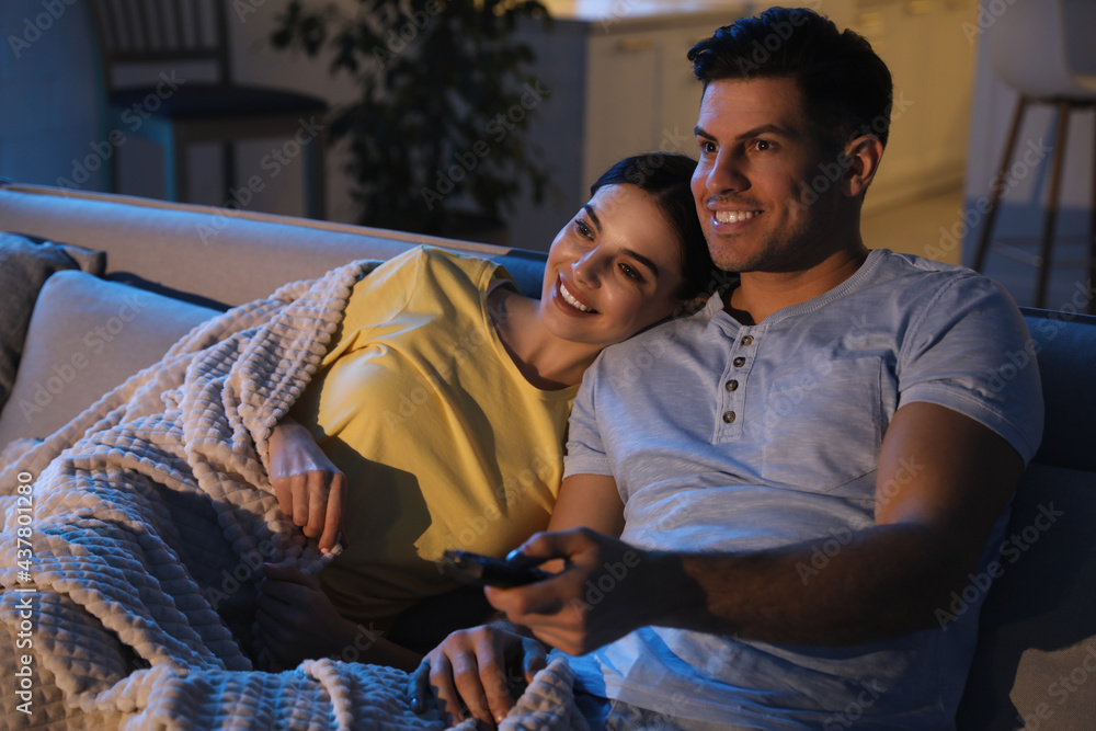 Couple watching movie on sofa at night Stock Photo | Adobe Stock