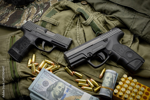 pistol, pistol with ammunition camouflage suit background The concept of weapons and self-defense equipment.