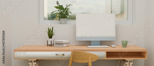 Computer device with mock-up screen on wooden desk with books and plant pot in home office, 3D rendering