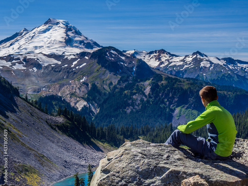 Teenager boy looking at Mount Baker from viewpoint on Chain Lakes Loop trail in North Cascades, Washington