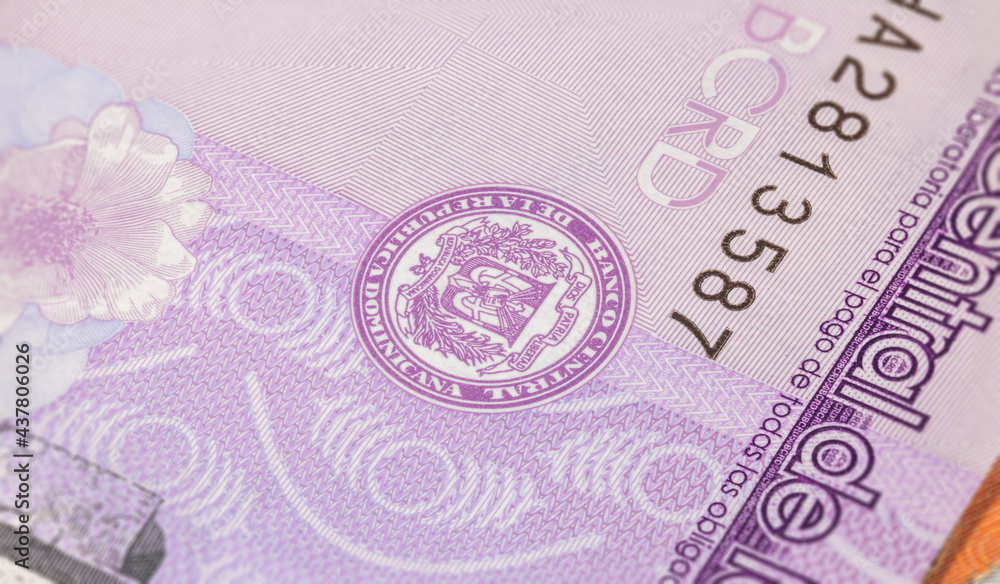Close up to fifty Pesos of the Dominican Republic. Paper banknotes of the Caribbean country. Detailed capture of the coat of arms and the serial number. Detailed money background wallpaper.