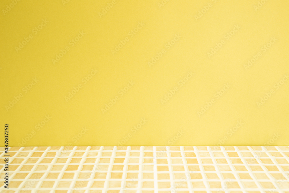 Yellow ceramic mosaic tile table. yellow wall background. Home interior