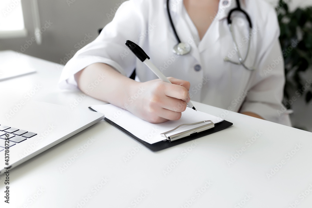 The doctor writes something in the patient's medical history The doctor writes something in the patient's medical history