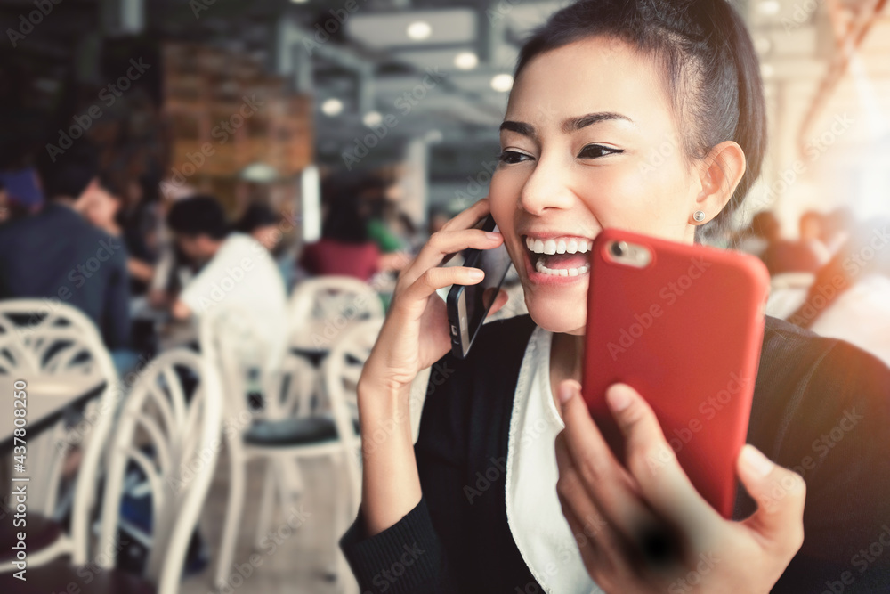 Asian woman smiling and laughing as she talks on his cell phone. focus on face Asian woman smiling and laughing as she talks on his cell phone. focus on face