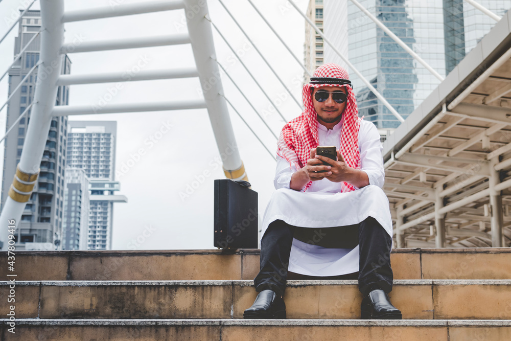 Islamic man using smartphones app organize schedule agenda focus on hands holding smartphone muslim modern uae city. Arab men wear hijab and muslim formal dress sending text sms online lifestyle Islamic man using smartphones app organize schedule agenda focus on hands holding smartphone muslim modern uae city. Arab men wear hijab and muslim formal dress sending text sms online lifestyle