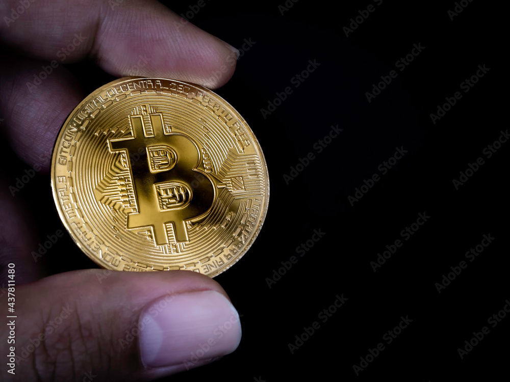 Bitcoin technology background. Close-up golden bitcoin in businessman's hand on black background with copy space. Digital Cryptocurrency investment concept background. Bitcoin technology background. Close-up golden bitcoin in businessman's hand on black background with copy space. Digital Cryptocurrency investment concept background.