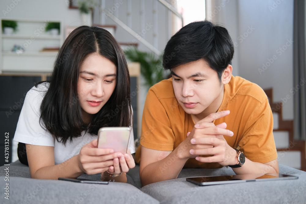 Happy young couple sitting relax on sofa in living room and have fun browse internet on tablet at home on weekend.
Happy young couple sitting relax on sofa in living room and have fun browse internet on tablet at home on weekend.