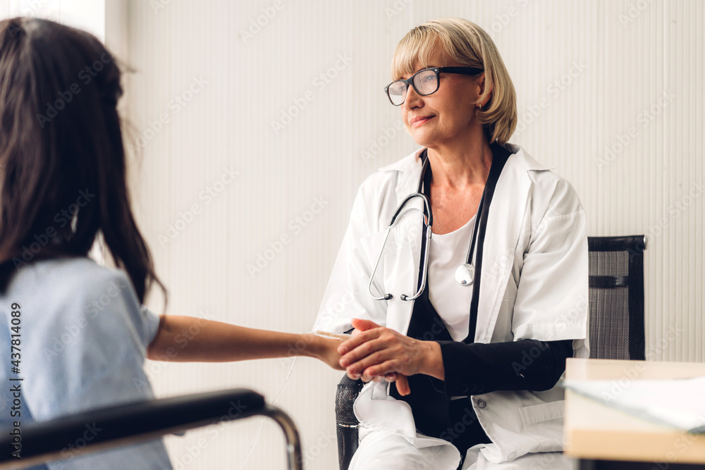 Fototapeta premium Woman doctor consulting and holding hand patient reassuring with care on doctors table in hospital.healthcare and medicine