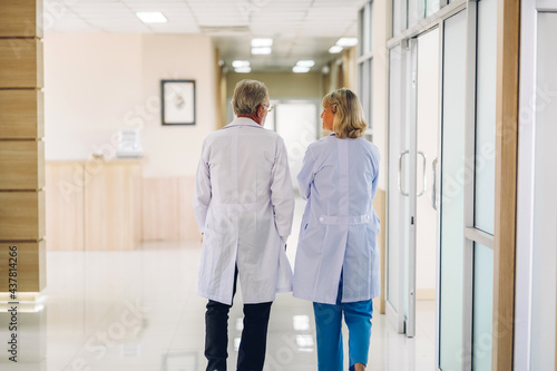 Group of professional medical doctor team with stethoscope in uniform working discussing and talk walking in hospital.health medical care concept