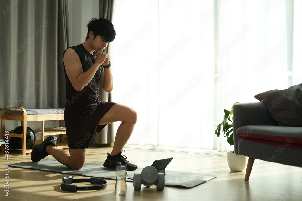 Young male in sportswear workout in living room. Young male in sportswear workout in living room.